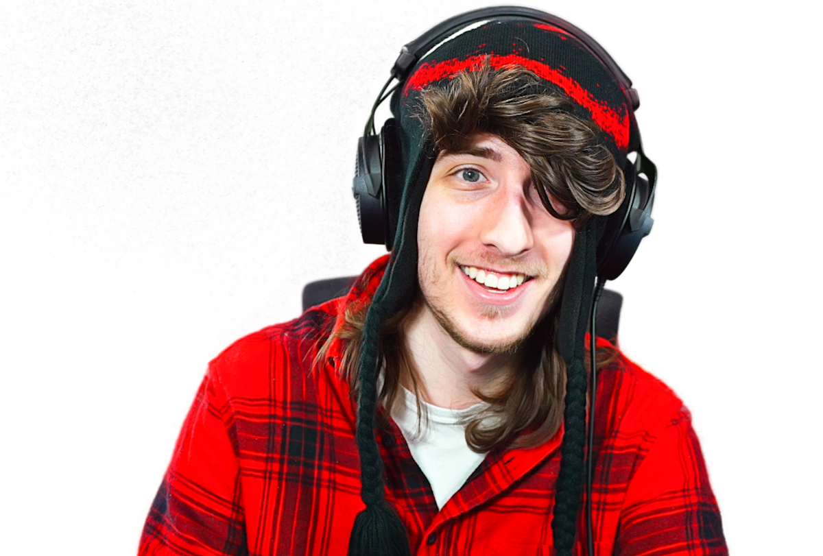 Roblox creator KreekCraft wearing a red plaid shirt and headphones
